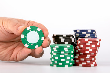 green casino chip in hand on white background