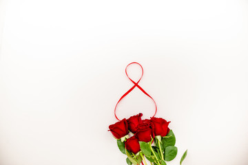 Bouquet of red  roses with a red ribbon. Eights march woman's day, holiday. Flowers on a white background copespace. Horizontal top view, number 8 in a ribbon