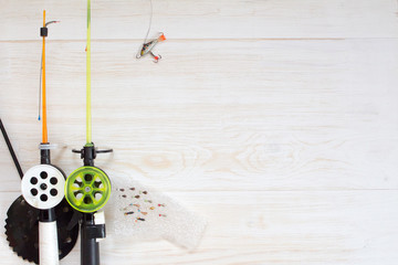 Tackle for winter fishing. Fishing rods and accessories on a wooden table. Top view