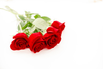 Bouquet of red  roses with a red ribbon. Eights march woman's day, holiday. Flowers on a white background copespace. Horizontal top view