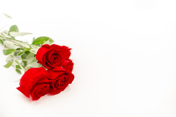 Bouquet of red  roses with a red ribbon. Eights march woman's day, holiday. Flowers on a white background copespace. Horizontal top view