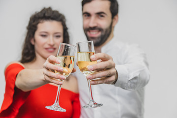 Loving young couple drinks champagne. On a white background. Dressed in red dress and white shirt.