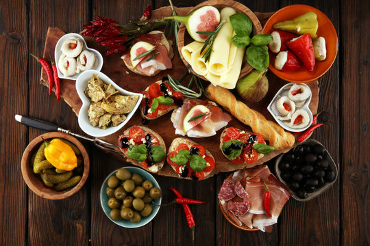 Italian antipasti wine snacks set. Cheese variety, Mediterranean olives, pickles, Prosciutto di Parma, tomatoes, artichokes