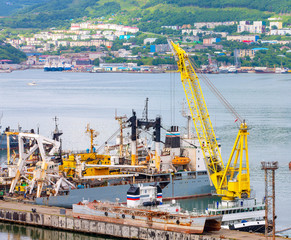 Fototapeta na wymiar The ships at pier, port cranes on commercial seaport Kamchatka
