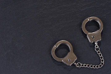 Closed silver handcuffs isolated on black background