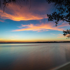 Fototapeta na wymiar Sunset over calm water. Myall Lakes, Australia