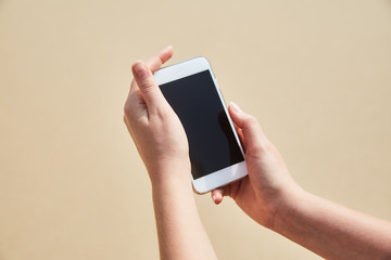 Mobile phone in female hand on the background of the beach and ocean