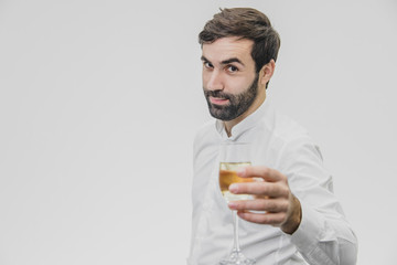 Cheerful young entrepreneur drinks champagne. During this celebrating Valentine's day. Dressed in white shirt.