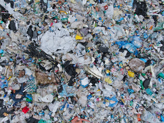 AERIAL: View from above of a stinky heap of garbage in a plastic sorting site