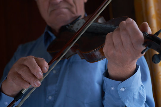 Caucasian Senior Man Playing The Violin.