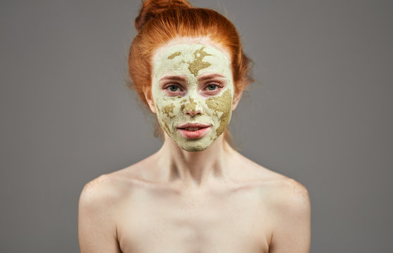 awesome girl is waiting the ressult of clay mask. close up photo