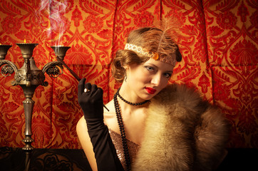 Girl in an evening dress with a cigarette. Studio retro style photo