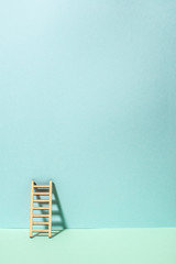 Wooden ladderr on wall. Pastel tones. Concept for success and growth.