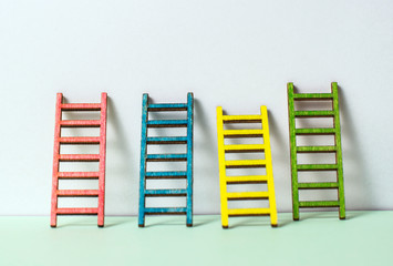 Multicoloured ladders on wall. Pastel tones. Concept for success and growth.