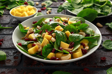 Mango Spinach salad with dried cranberries and nuts. healthy food.
