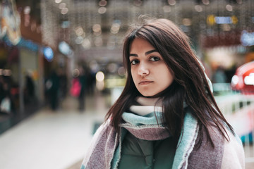 Fototapeta premium stylish,brunette,winter season,pretty,fashion,scarf,cheerful,attractive,fair lights,close up,portrait,interior,entertainment center,mall,background,caucasian,smile,cafe,cute,lady,looking,face,white,pe
