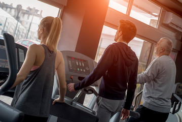 Group of people exercising together on treadmills at the gym  