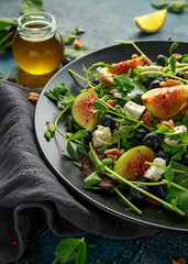 Figs salad with blueberries, walnuts, feta cheese and green vegetables. healthy food