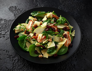 Pear, chicken salad with cheddar cheese, cranberry and walnuts. healthy food. black stone background