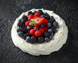Berry Pavlova cake with fresh blueberries, strawberries and raspberries
