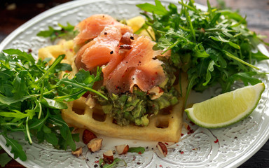 Potato waffles with avocado guacamole and smoked salmon for breakfast