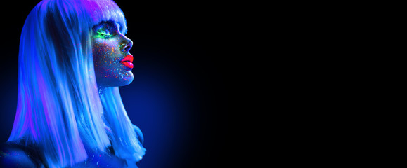 Fashion model woman in neon light. Beautiful model girl with colorful bright fluorescent makeup isolated on black. Ultraviolet, UV