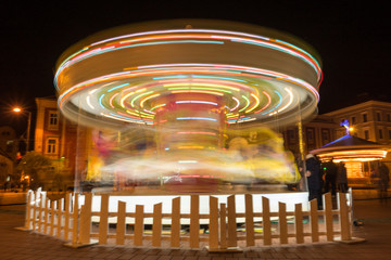 View of a spinning carousel for kids. Night scene. Long exposure.