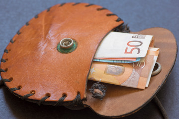 An old brown purse with money inside