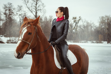 Fashionable woman walking on horseback.