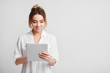 Obraz premium Woman using digital tablet over grey background