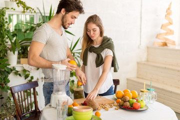 good loking man and woman making salad from different fruits. close up photo. wellness, wellbeing. copy space