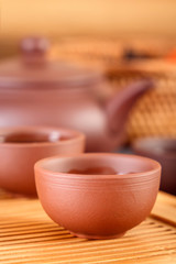 brown ceramic cups with a teapot on a special wooden tea tray prepared for a traditional Asian tea ceremony. Close-up