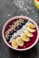 closeup top view shot of a tasty delight on the table.dessert with seeds, bananas, blueberries and coconut flakes