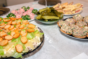 A variety of dishes on the festive table. Chicken salad with pineapples and crackers and other dishes. Holiday food, soft focus.