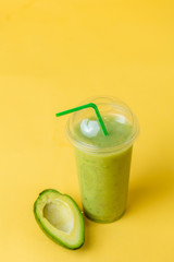 fresh beverage from avocado, broccoli, lettuce, cucumbers. isolated yellow background