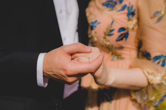 Bridal couple holding hands. Close-up picture without faces.