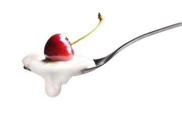 Plain yogurt on a spoon with fresh cherry on top isolated on white background