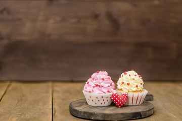 Cupcakes with heart on wooden background. Empty space for text