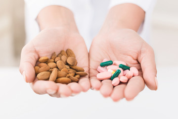 Natural food concept, almonds comparing vitamins in doctor hands