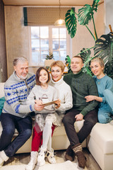 attractive cheerful big family has gatehred together in the house. care. pleasant memories from the...