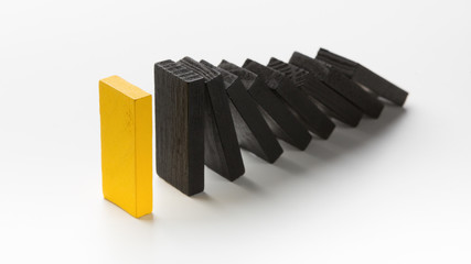 One yellow wooden block stop other ones falling like dominoes