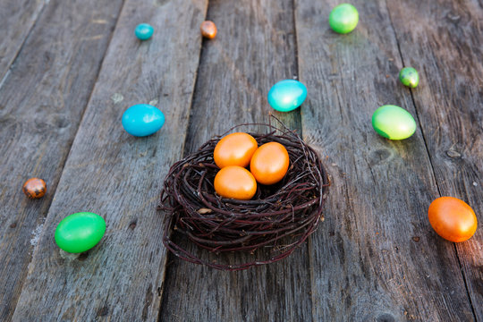 Colorful Easter egg in the nest on wooden background