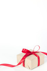 Present or gift box in a craft paper with gold ribbon bow