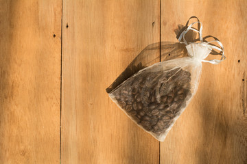 Coffee beans sourvenir in a small bag on wooden background, Wedding sourvenir concepts