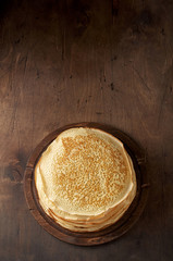Stack of russian pancake blini on a wooden background