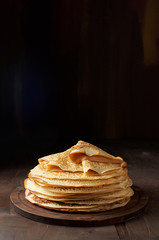 Stack of russian pancake blini on a wooden background