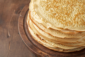 Stack of russian pancake blini on a wooden background