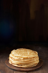 Stack of russian pancake blini on a wooden background
