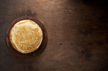 Stack of russian pancake blini on a wooden background