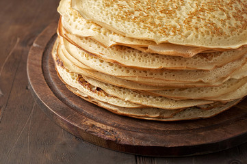 Stack of russian pancake blini on a wooden background